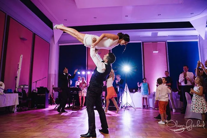 Un couple de mariés danse entouré de ses invités